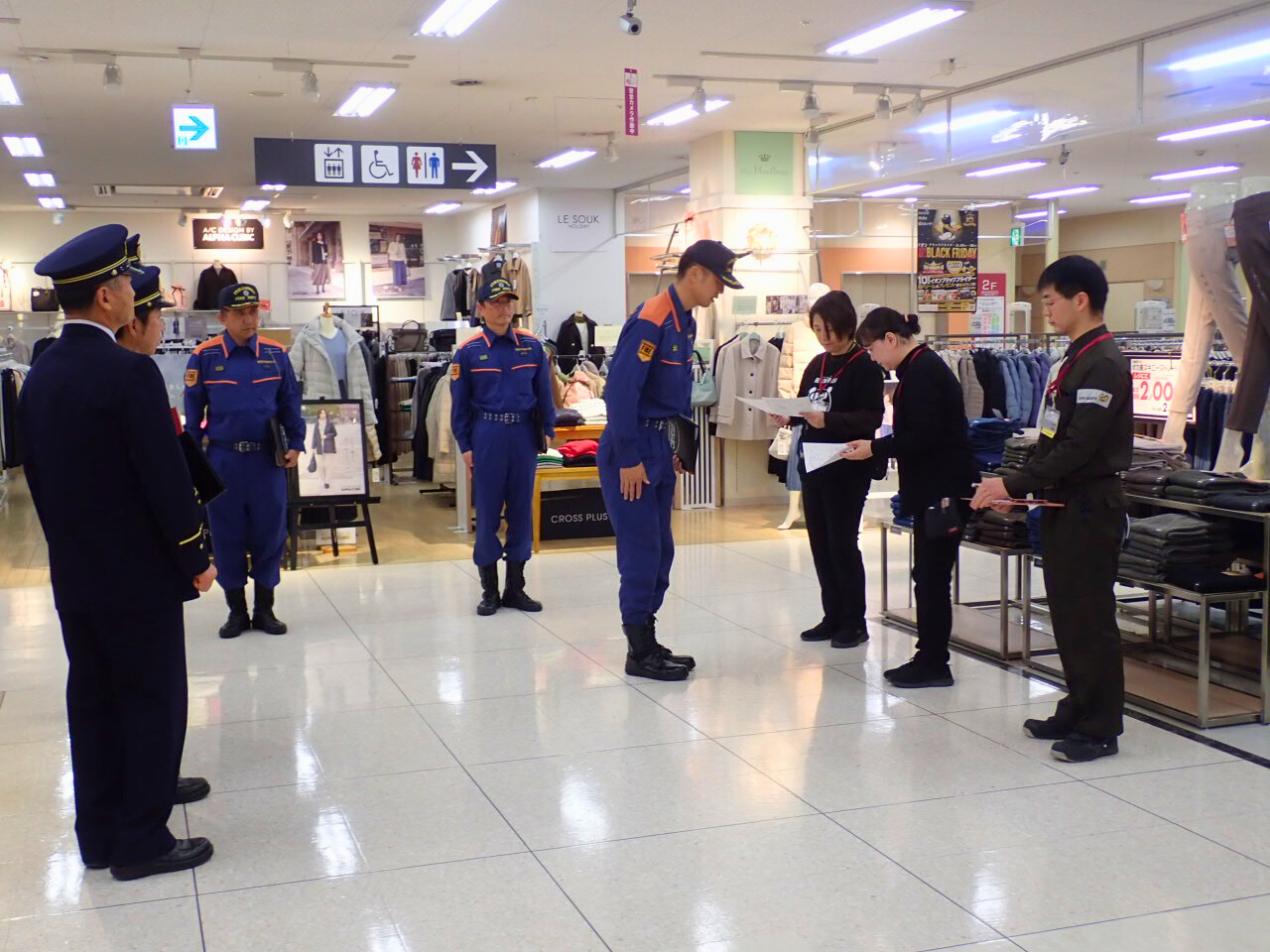 検査担当職員から商業施設従業員へ事前に検査の流れを説明している様子