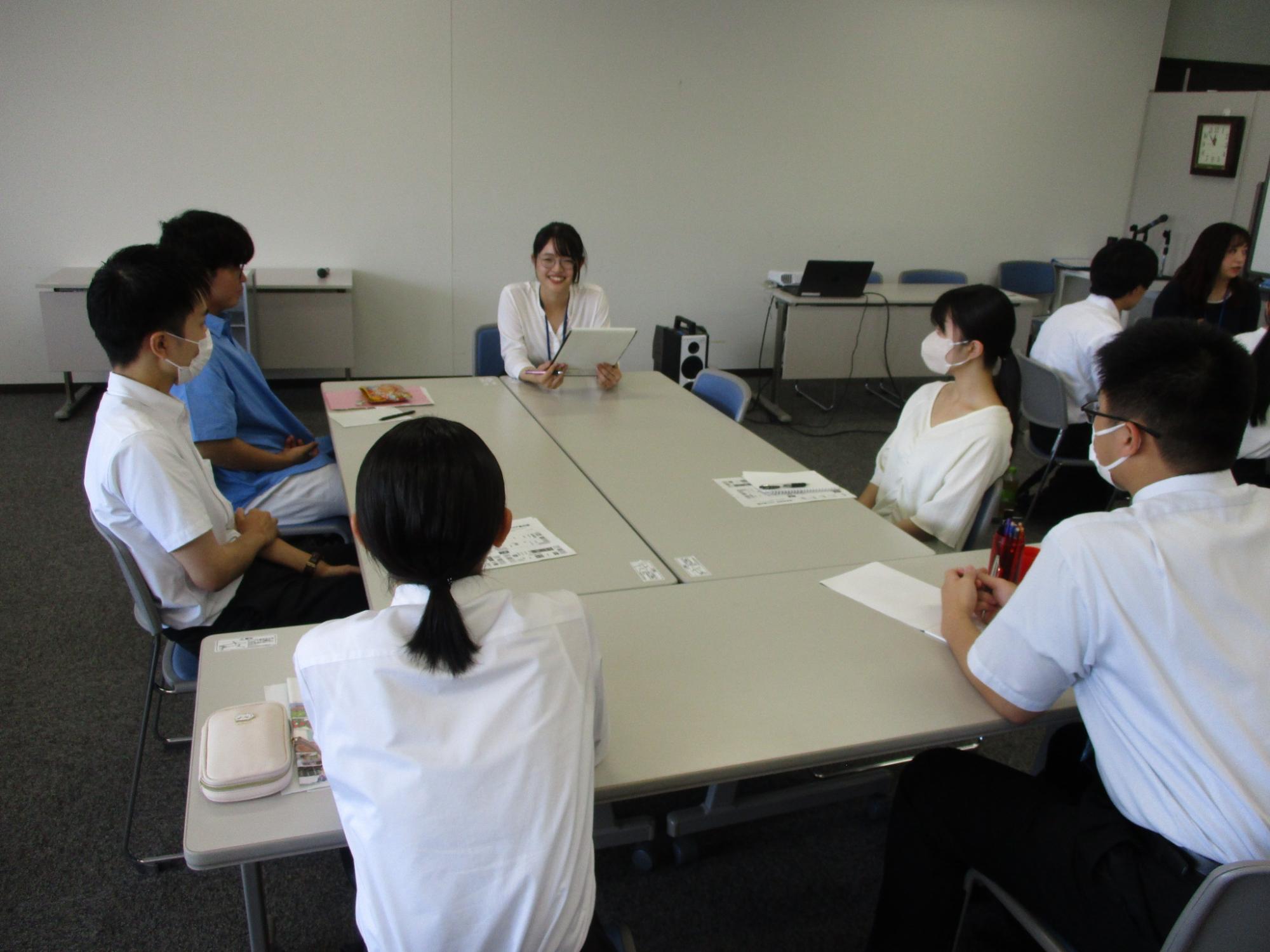 テーブルを囲んで女性職員が前に座り若手職員との交流会が行われている写真