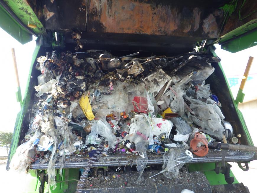 燃えたカセットボンベやスプレー缶が黒くなった、ごみ収集車荷箱内の写真