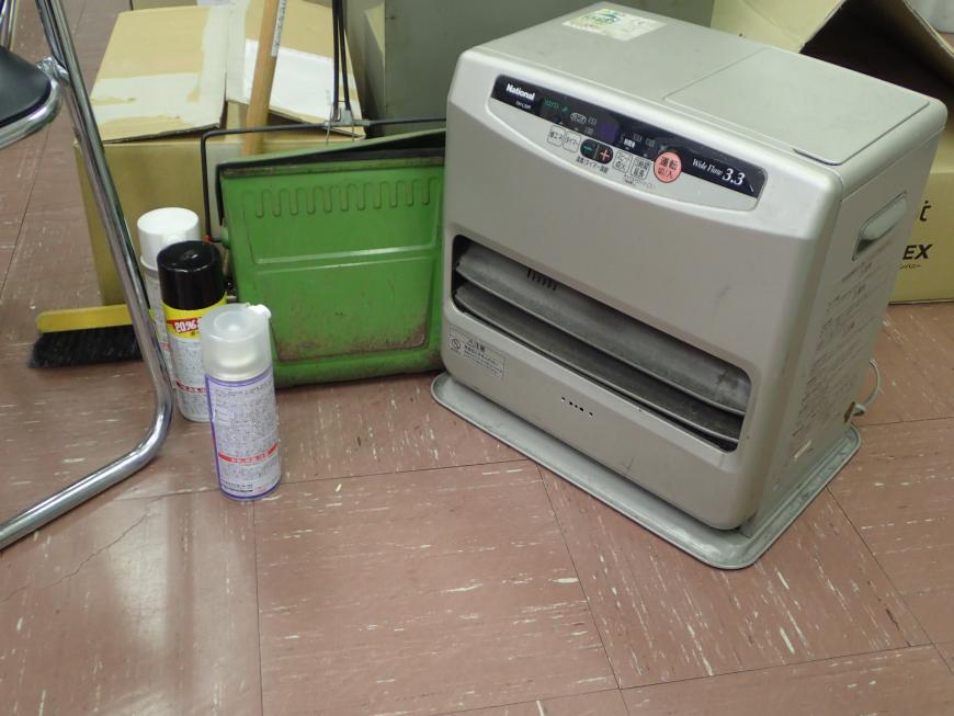 ファンヒータの前に3本のスプレー缶が置かれた写真