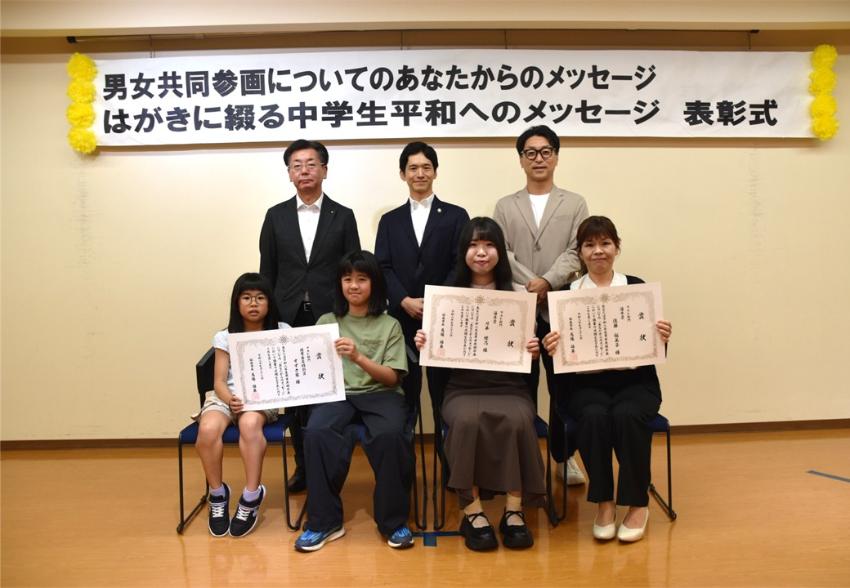 フォト部門の入賞者が座り賞状を見せながら笑顔で記念撮影をしている写真