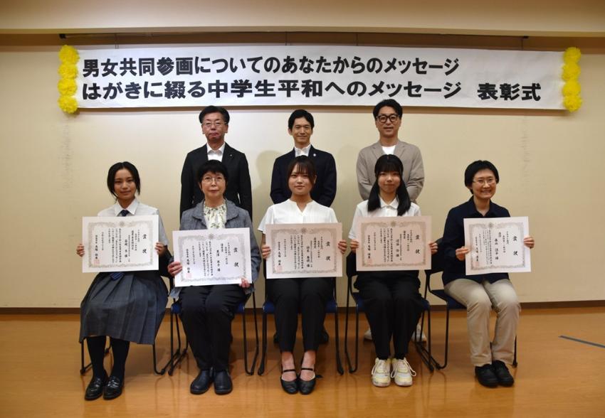 高校生一般の部の入賞者が座り賞状を見せながら笑顔で記念撮影をしている写真