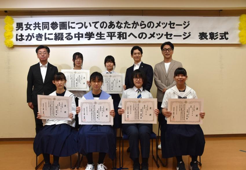 中学生が賞状を見せながら笑顔で記念撮影をしている写真