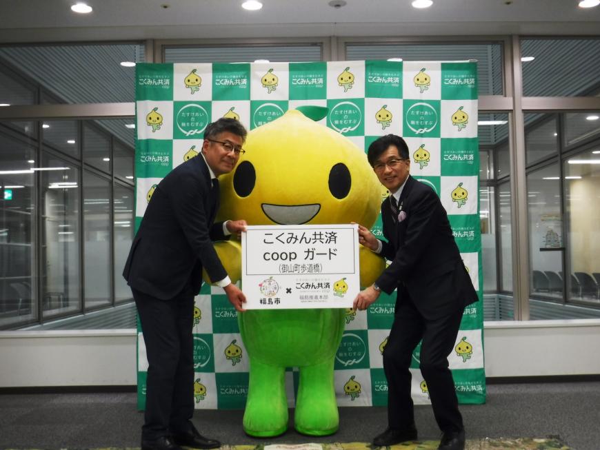 左から、八巻正一様、ピットくん、福島市長が並び国民共済COOPカードと書かれたプレートを持って記念撮影をしている写真