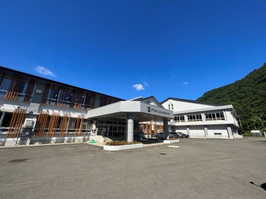 2階建て白の外壁で入口にFOM ACADEMYと書かれたFOMアカデミーの入口付近を写した外観写真