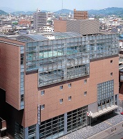 5階建てで全体的にベージュ色、上の階はガラス張りになっている建物のキョウワグループ・テルサホールの外観写真