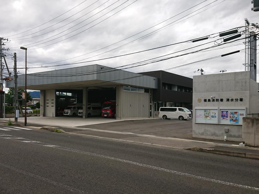 「福島消防署清水分署」と書かれた看板の奥に、道路に面した消防車や救急車が駐車された車庫がある写真