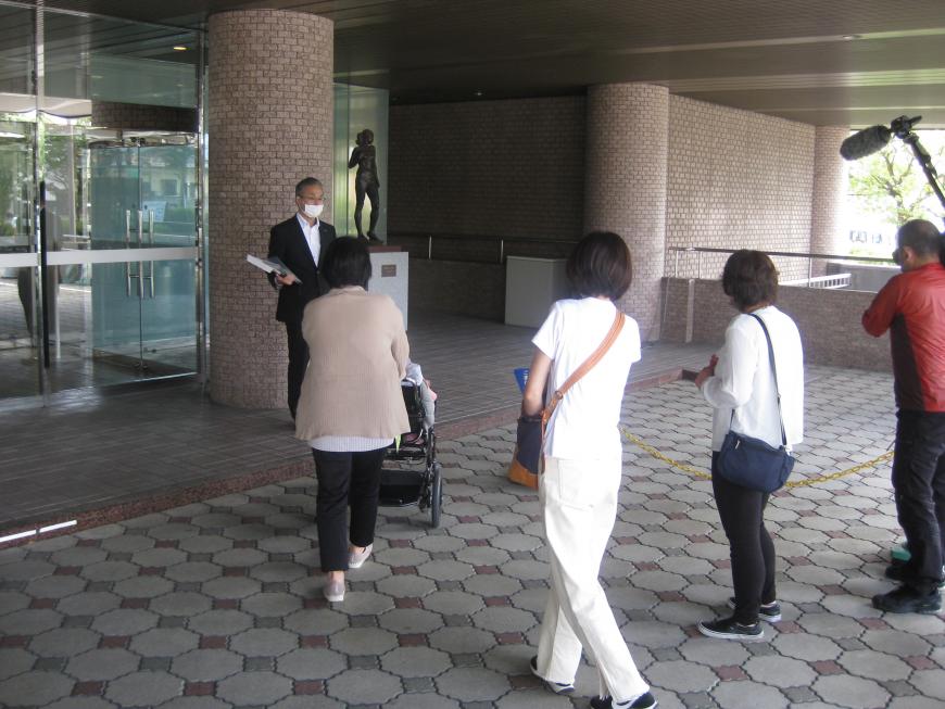 係の方の案内で、参加者の方々が駐車場の様子を確認している様子の写真