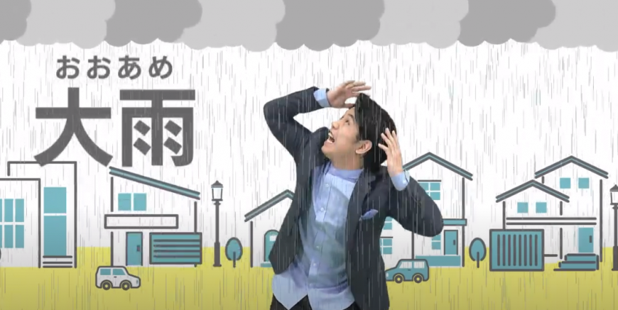 大雨についての動画の映像の写真(大雨の中、男性が傘を差さずに濡れて空を見上げている様子)