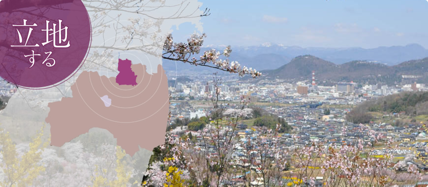 立地する(福島市の位置図とピンク色の花が咲いた高台から市街地を撮影した写真)