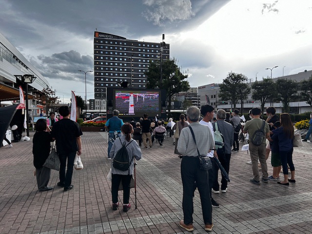 福島駅西口駅前広場に設置されたパブリックビューイングの前に大勢のファンが集まっている様子の写真
