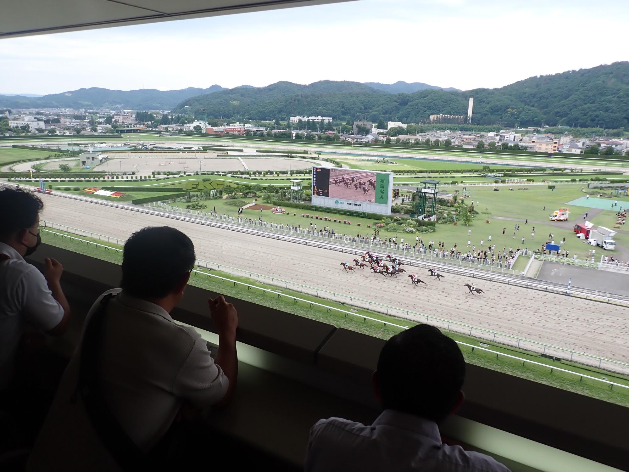 競馬場の来賓室で競馬を楽しんでいる会員の方々の写真