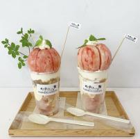 木製トレイの上に店の名前が書かれたラベルが貼られた透明の容器の上に桃がまるごと一個のっている2つのパフェの写真