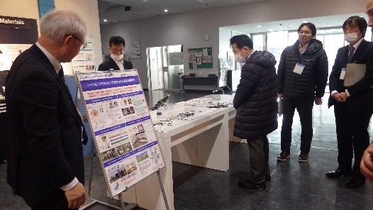 白い台の上に置かれた展示品を参加者が見ている写真