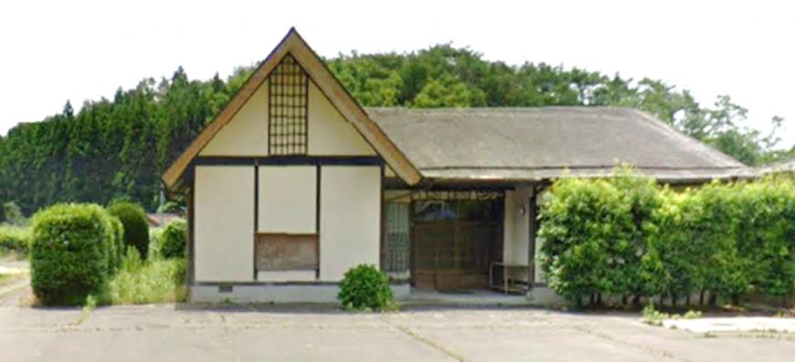 左側は三角屋根で、白壁でL字型の中野生活改善センターの建物外観の写真