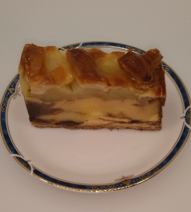 白皿に盛り付けられたパイとケーキの間にりんごの果実を挟んだアップルジャーマンの写真