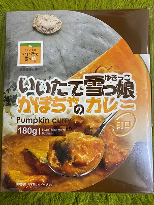 大きなかぼちゃの写真の下半分にスプーンですくったカレーの写真が重なったデザインで、中央に「いいたて雪っ娘かぼちゃのカレー」と書かれている商品パッケージの写真