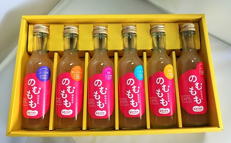 黄色のケースに「のむもも」と書かれたピンク色のラベルが貼られた6本の瓶入りの商品が並んでいる写真