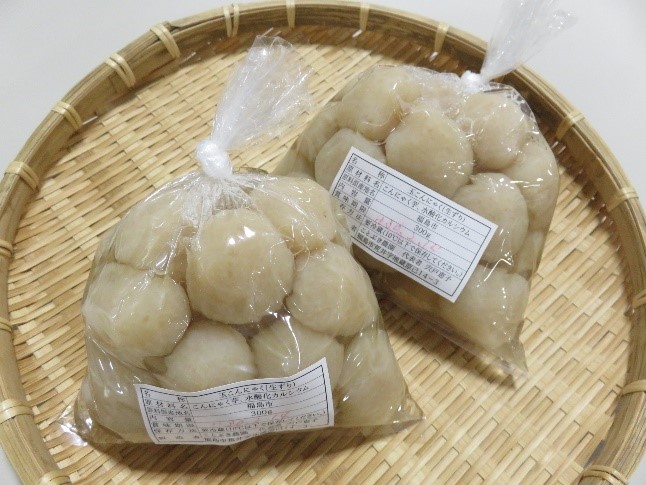 ザルの上に透明袋に入った2袋の手作り玉こんにゃくの商品が並んでいる写真