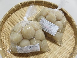 ザルの上に透明袋に入った2袋の手作り玉こんにゃくの商品が並んでいる写真