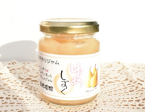 商品名「ゆめしずく」と書かれデザインされた白のラベルが貼られた透明の円柱型のジャム瓶に、洋梨の果肉を残した淡いベージュ色のジャムが入った商品の写真