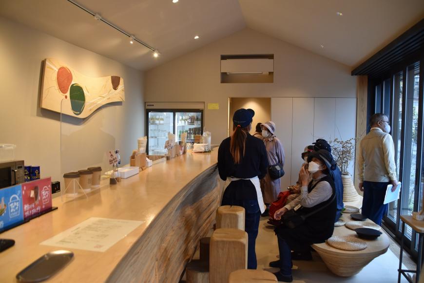 店内のカウンター前にある椅子に参加者達が座り店員さんの話を聞いている写真