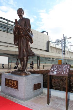 俳句を詠んでいる松尾芭蕉のブロンズ像の写真