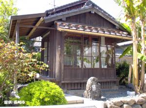 大きな石に「如己堂」と書かれ、その後ろに和風な如己堂がある外観写真