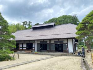 周囲に木が植えられ和風な旧佐久間邸を正面から撮影した外観写真