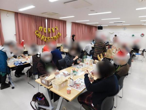 イベントに参加した男女が各テーブルに分かれてハーバリウムオイルランプ制作をする様子の写真