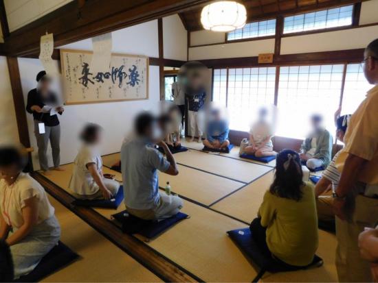 座布団の上に座った参加者達が円になり話をする様子の写真