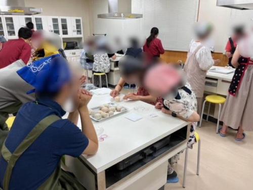 イベントに参加した男女が料理をする様子の写真