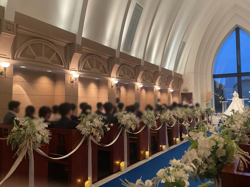 イベントに参加した男女がチャペルの席に座っている様子の写真