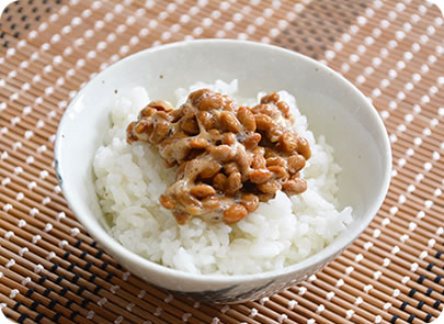 お茶碗によそいだご飯の上に納豆を乗せた写真