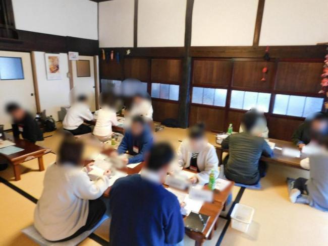 テーブルが4ヵ所設置された和室でグループに分かれて話をしている様子の写真