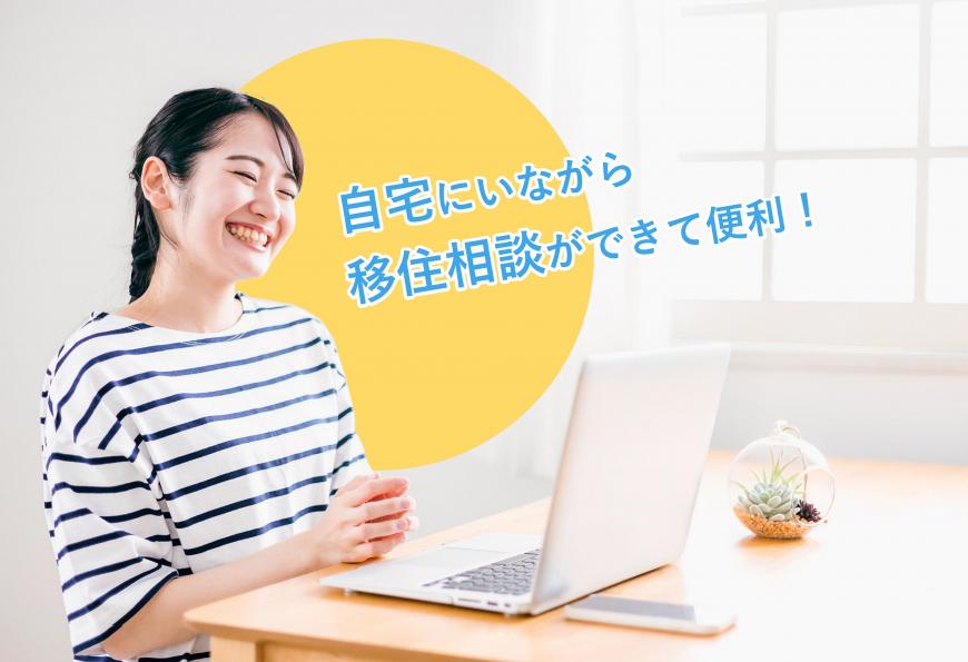自宅にいながら 移住相談ができて便利! パソコンの前に笑顔で座っている女性の写真