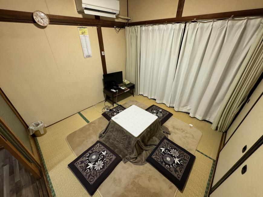畳の敷かれた和室に炬燵が置かれた室内写真
