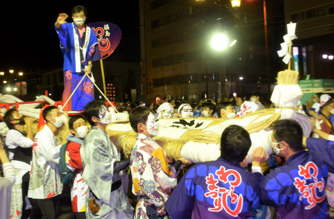 大きなわらじに青い法被を着た木幡市長が乗って盛り上げている様子の写真