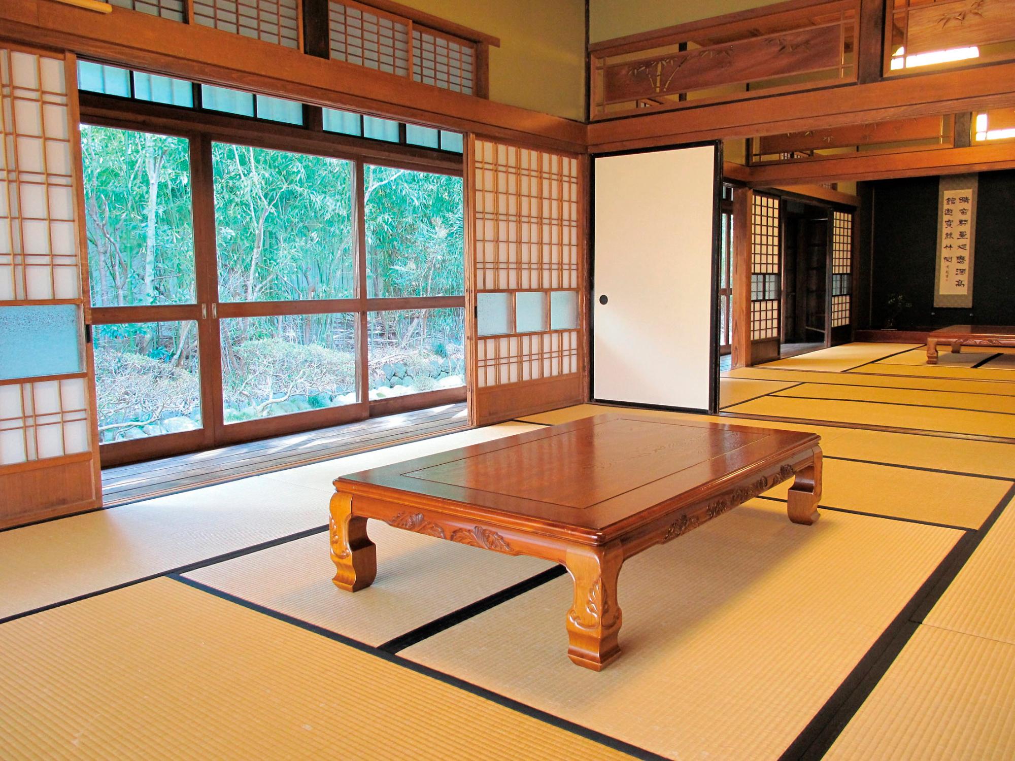 畳の敷かれた二間続きの和室にテーブルが置かれた写真