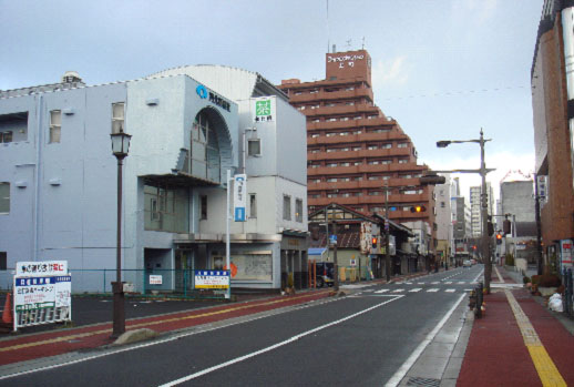 中央に2車線の道路、両側にビルなどが並んでいる街並みの写真