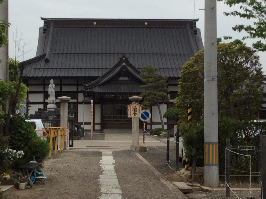 砂利道の中央に一直線に敷かれた敷石の先に建っている東安寺を正面から写した写真