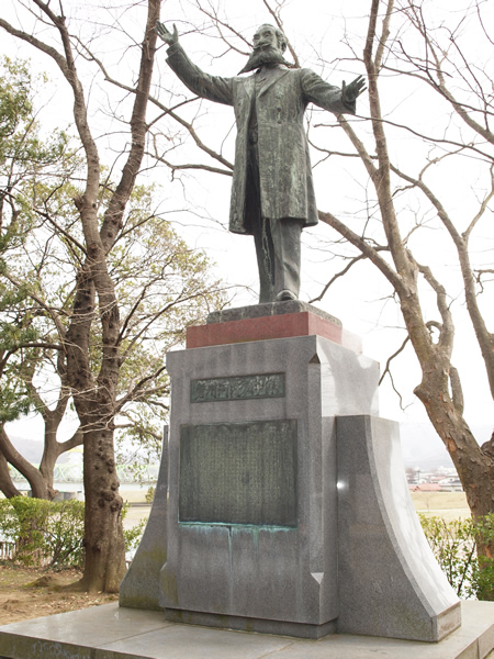 台座の上に両手を広げて立っている河野広中の石像の写真