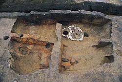 遺跡の一部の地面が周りの地面の異なり赤くなっている中期の焼けた家の跡が見られる写真