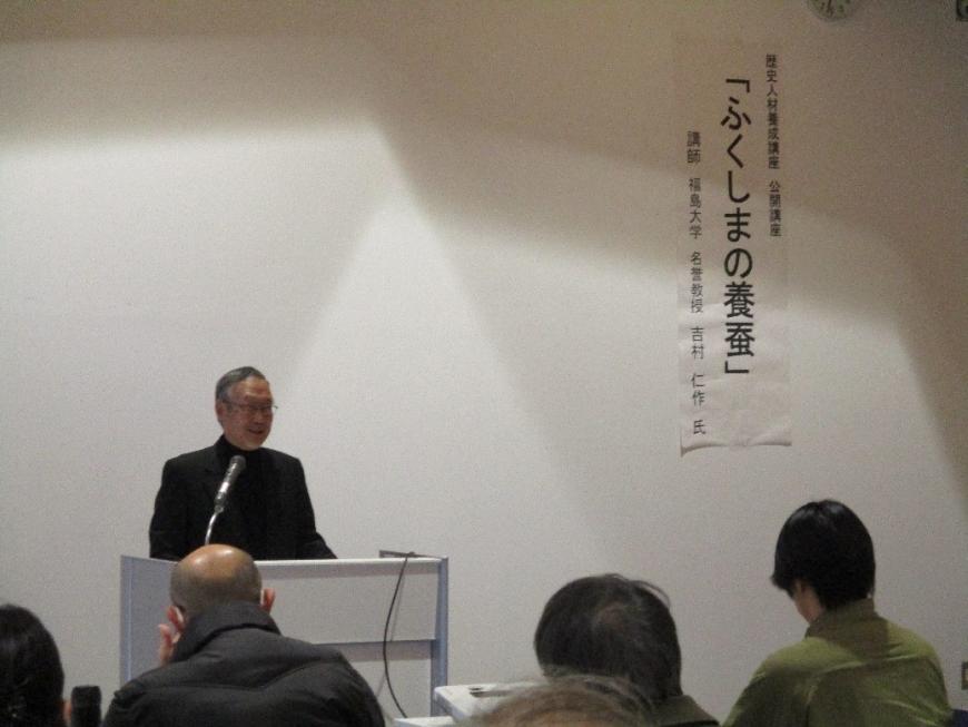 講師が壇上に立ち「ふくしまの養蚕」について参加者たちに話している写真