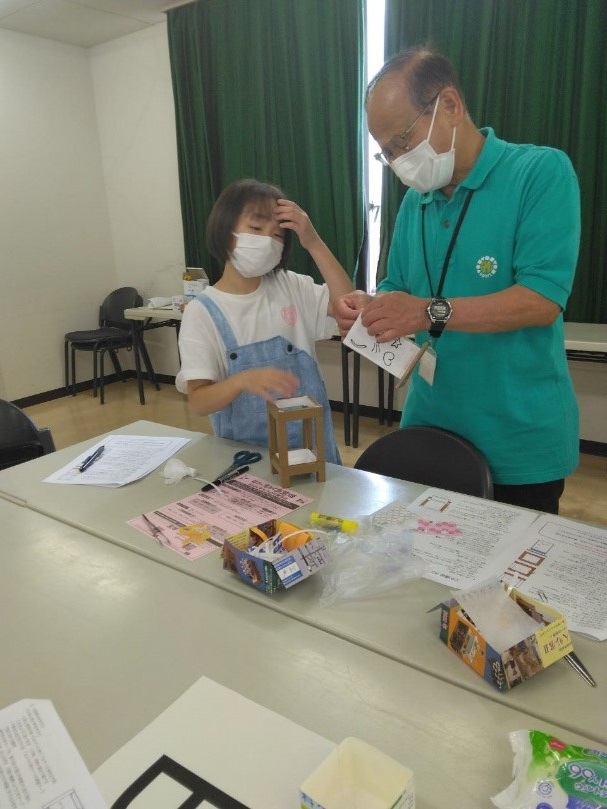 男性と女の子が行灯に付ける装飾をどれにするか楽しそうに話している写真