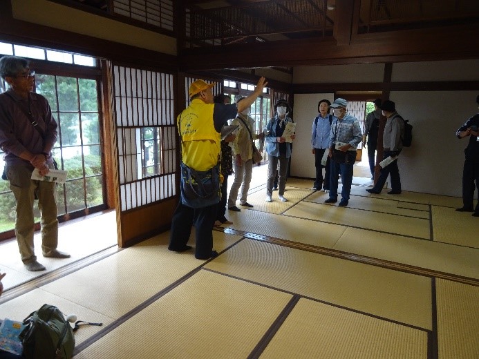 御倉邸がどのように造られたのかを講師の説明を聞き見て回る受講者たちを撮影した写真