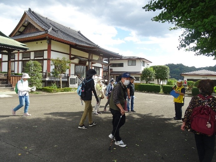 宝林寺の前にあるスペースに集まり講師から説明を受ける受講者たちを撮影した写真