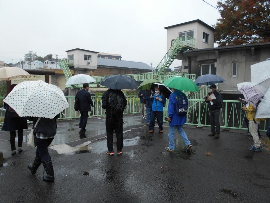 西根下堰について説明する講師と周りに集まり話を聞く受講者の写真