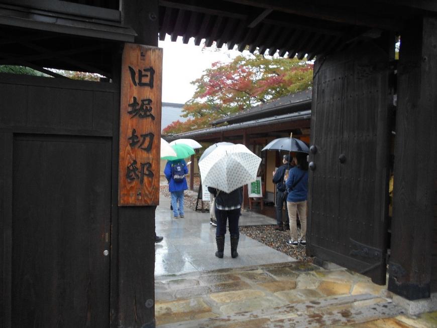 旧堀切邸と書かれた表札がかかる門の入り口で集まる受講者の写真