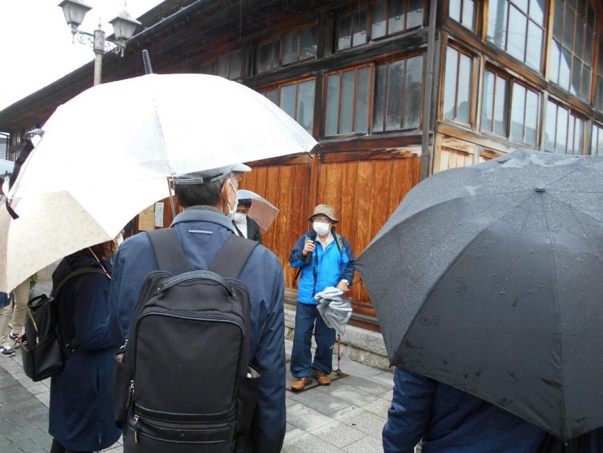 鯖湖湯の前で説明をする講師と話を聞く受講者たちを撮影した写真